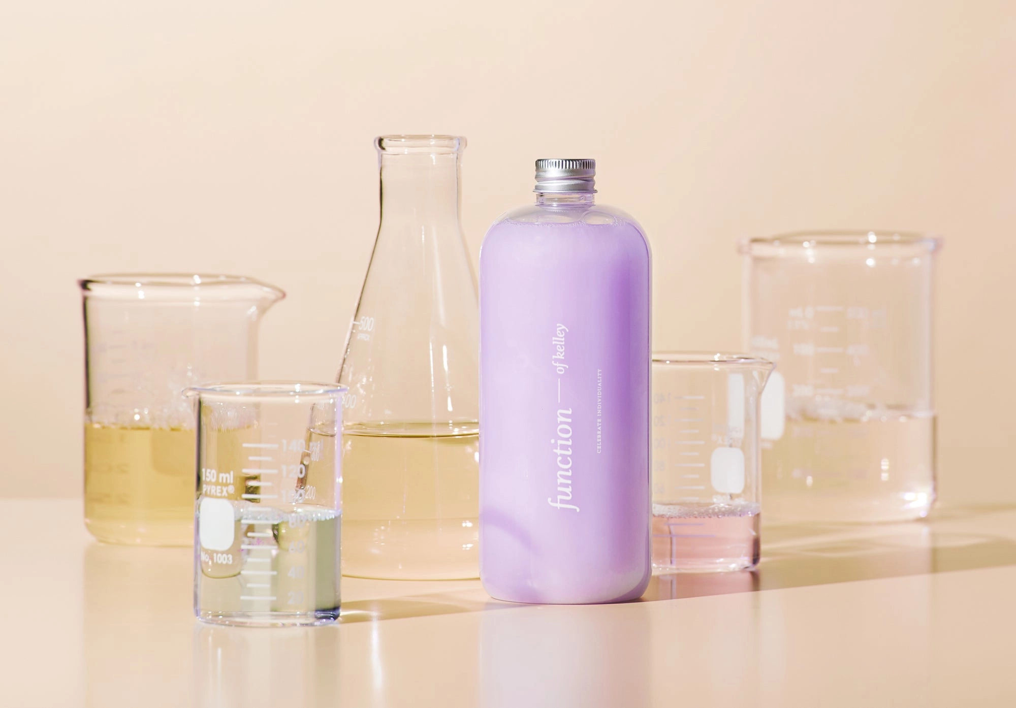 Glass beakers and flasks with a lilac bottle in a formulation lab
