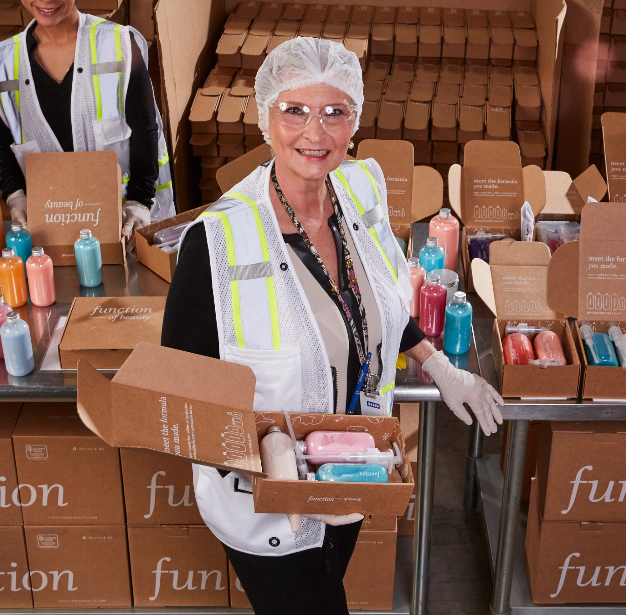 Team member in a safety vest packing Function of Beauty boxes