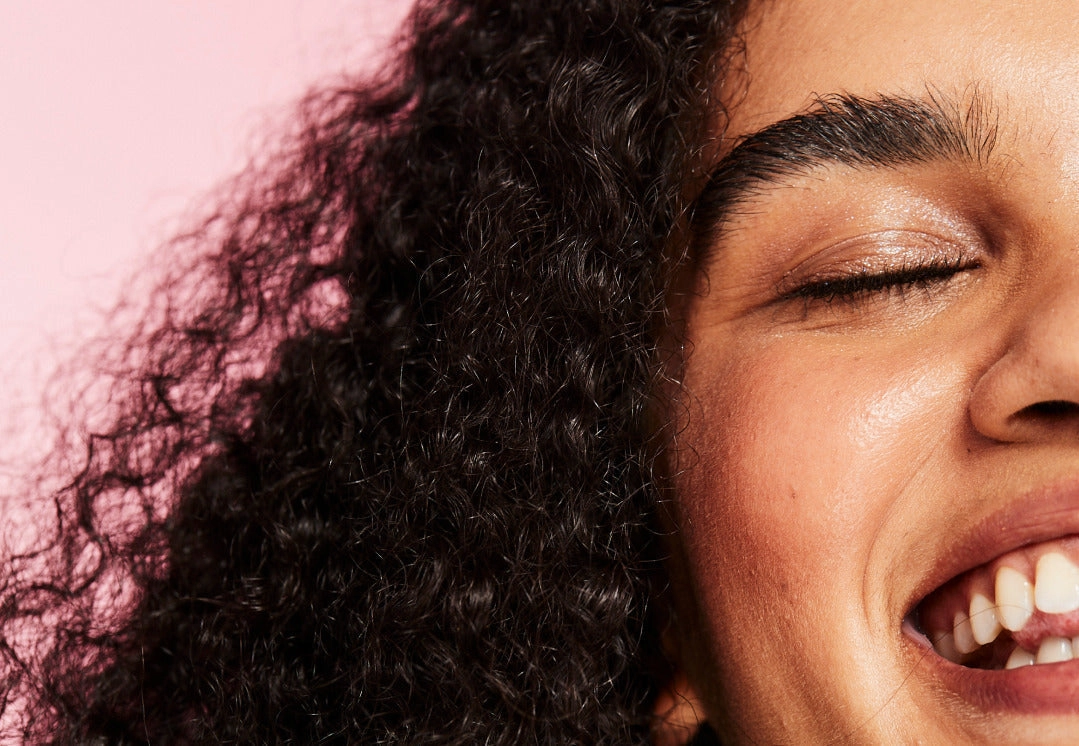 Close portrait of a laughing person with natural curls
